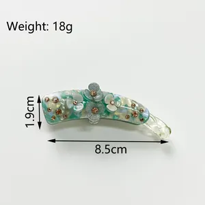 Banana hair clip with clover flower design and glitter details measuring 8.5cm long