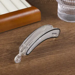 Detalle de una pinza para el pelo tipo banana en acrílico con nácar y texto impreso France