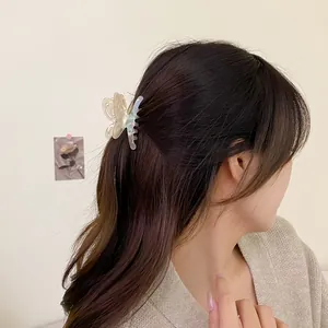 Pearlescent hollow butterfly hair claw clip with gradient purple and cream tones on hair
