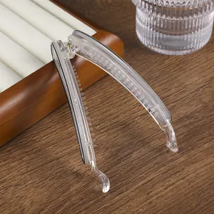 Detalle de una pinza de banana transparente grande con dientes internos tipo peine fino