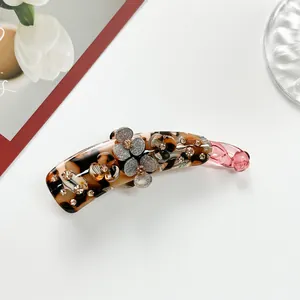 Detail view of flower banana clip with tortoise resin and sparkling champagne rhinestones