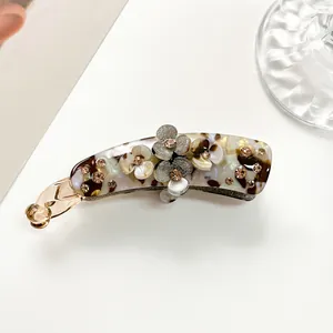 Close-up of banana hair clip with tortoiseshell texture and sparkling flower details