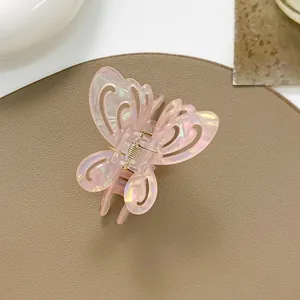 Macro shot of pink butterfly hair claw with iridescent laser finish and hollow design