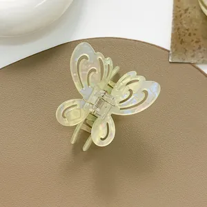 Detailed macro of a hollow butterfly hair claw clip with pearlescent finish and metal spring