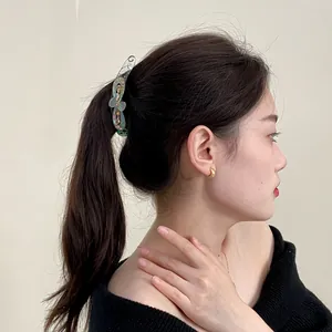 Barrette banane élégante avec nœud et strass portée sur une queue de cheval de mannequin