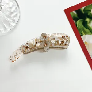 Detailed macro view of a resin banana clip with marble texture and glittery floral design