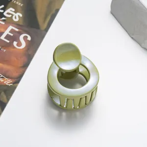 Detail of light green 3.5cm round hair claw clip with pearlescent glitter finish