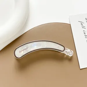 Detalle del clip de pelo tipo banana grande blanco jaspeado con logotipo de France
