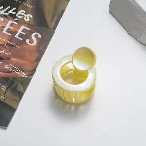 Close-up of a 3.5cm glittery pale yellow round hair claw clip on a stylish background