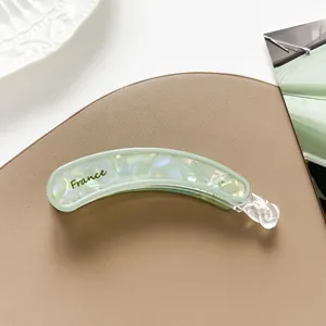 Detalle de pinza de pelo tipo banana verde menta nacarado con texto France lateral