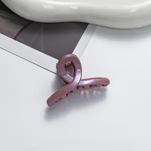 Gros plan sur la pince à cheveux lilas pailletée élégante au design torsadé moderne