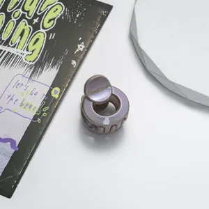 Detail of mini round glitter claw clip with purple iridescent finish for hair styling