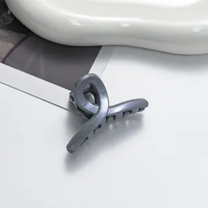 Gros plan d'une pince à cheveux gris foncé pailletée avec lignes entrelacées