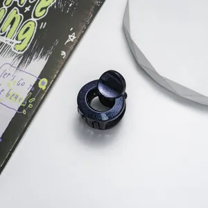 Detail view of mini dark blue glitter hair claw clip on white geometric display stand