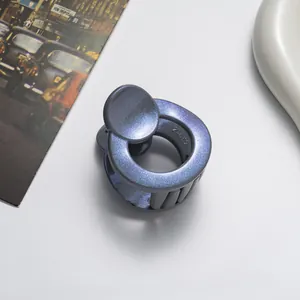 Macro shot of 3.5cm glittery blue hair claw clip with model number Z-052 on white desk