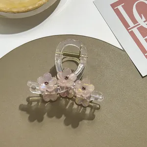 Detail van roze harsbloemen met strass steentjes op een transparante haarklem