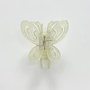 Detailed top view of a hollow butterfly-shaped hair claw clip in creamy yellow