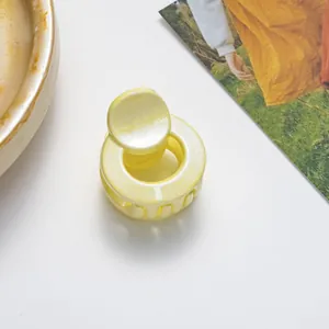 Detailed view of mini yellow glitter hair claw clip with a glossy finish for hair styling