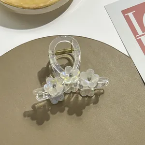 Macro-opname van transparante haarklem met parelachtige vijfbladige bloemen en luxe strass