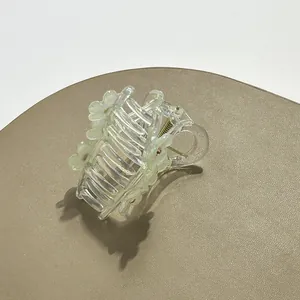 Detail van lichtgroene bloem haarklem met strassteentjes en stevige metalen veer