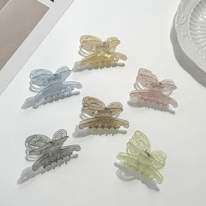 Detailed close-up of six butterfly hair clips in soft pastel resin colors on white display