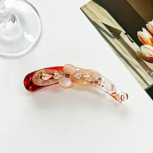 Détail de la pince banane en résine ambrée ornée d'une fleur en cristaux étincelants