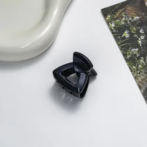 Detailansicht der dunkelblauen dreieckigen Haarspange mit Glitzer-Finish und Haltezähnen