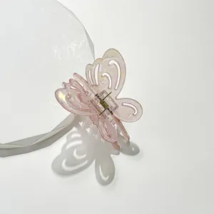 Pink holographic butterfly hair claw clip with pearlescent finish on white stone base