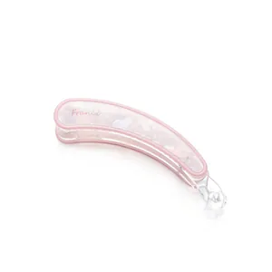 Detalle de pinza banana de acrílico jaspeado rosa con texto France y cierre transparente