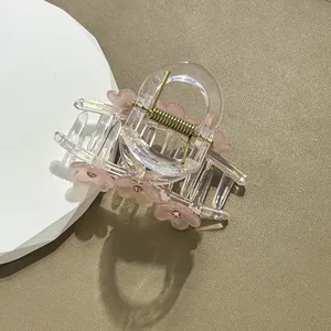Detailopname van roze haarklem met bloemen en strass-steentjes op beige lederen basis