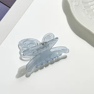 Macro detail of iridescent butterfly hair claw clip with cutout wings and shiny metal spring