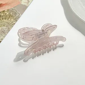 Close-up of translucent light pink butterfly hair claw clip with glossy resin finish
