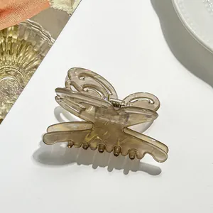 Detail shot of a hollow butterfly hair claw clip in amber resin for half-up hair styles