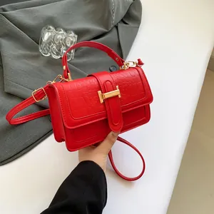Elegante borsa rossa con trama a coccodrillo, chiusura dorata e manico corto