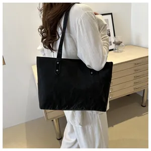 Detail of matte black tote bag with unique pleated texture and silver rivet accents