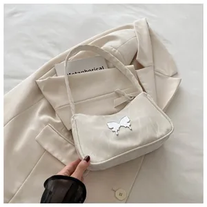 Macro detail of white marble textured bag with a silver butterfly buckle on beige blazer