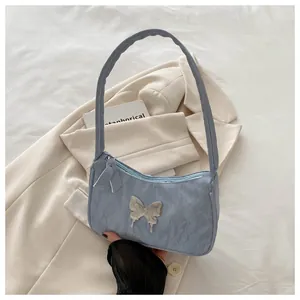 Close-up of light blue pleated shoulder bag featuring a silver 3D butterfly metal buckle