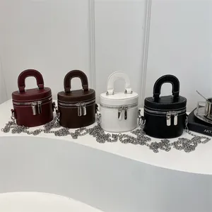 Borse a secchiello cilindriche in quattro colori con cuciture e catene in metallo