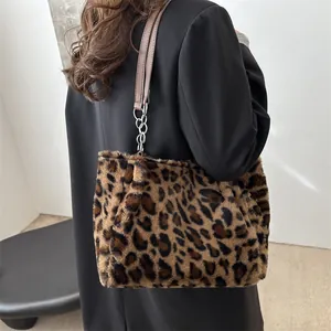 Sac fourre-tout en peluche léopard avec bandoulière en cuir et chaîne porté par un mannequin