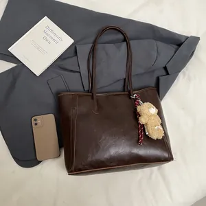 Vintage dark brown large tote bag with shoulder straps and a plush bear charm decoration