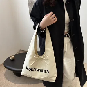 Grand sac cabas en toile blanc cassé avec lettrage noir et détail de nœud élégant