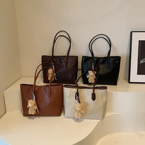 Large vintage leather tote bags in four classic colors with cute bear charms on white steps