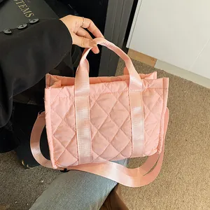 Pink quilted nylon handbag with top handles and adjustable wide crossbody strap