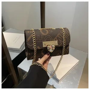 Bolso bandolera marrón vintage con estampado de monograma y cadena dorada de corazón