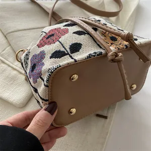 Ethnic style jacquard bucket bag with floral patterns and leather base including feet