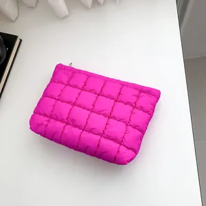 Pink quilted down clutch bag with square patterns and golden zipper on white background
