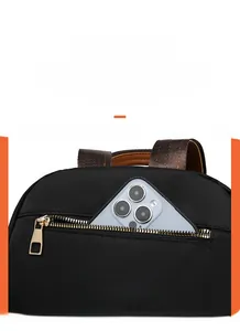 Detail of a hidden anti-theft zipper pocket on a black oxford fabric backpack with a phone