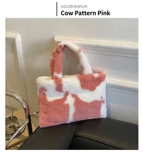 Close-up of plush pink cow print tote bag with soft faux fur texture and handles
