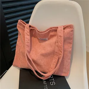 Pink corduroy tote bag with fashion tag on a white chair, stylish shoulder handbag for women