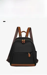 Detail shot of black Oxford fabric backpack with premium brown leather trim and zips